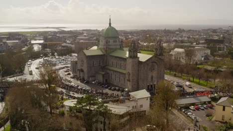 paralaje aéreo de la catedral de galway mientras las familias se reúnen para ver el desfile en irlanda
