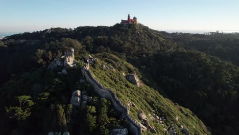 Luftaufnahme-Der-Vom-Sonnenlicht-Beleuchteten-Maurenburg,-Die-Auf-Der-Spitze-Des-Hügels-In-Zentralportugal-über-Der-Stadt-Sintra,-Lissabon,-Portugal-Steht