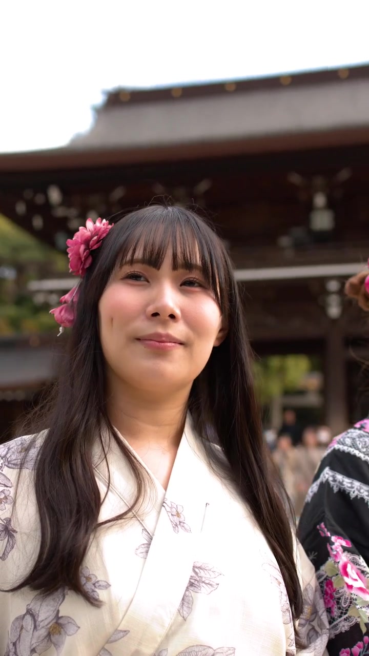 Due donne che indossano kimono tradizionali si inchinano rispettosamente presso un santuario storico giapponese a Tokyo.