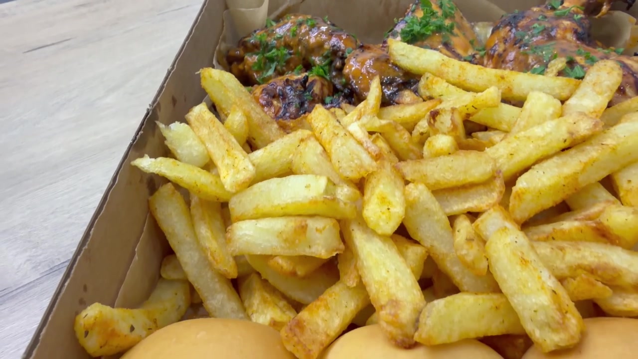 Frango Peri Peri em uma caixa com batatas fritas.