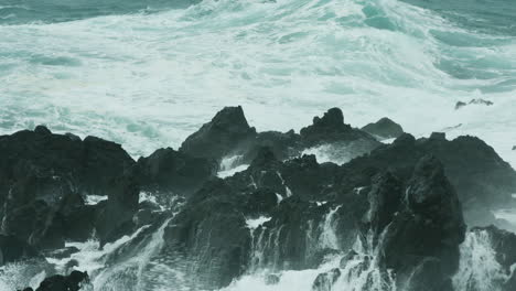 dramatic close up of waves crashing over rocks