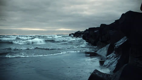 powerful iceland storm waves crashing against stone rock cliffs