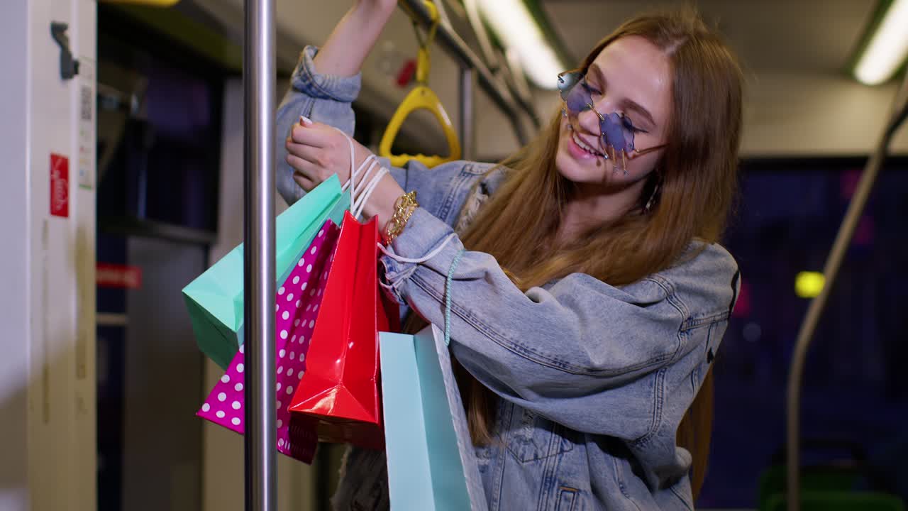 mujer joven adicta a las compras divirtiéndose después de comprar con bolsas brillantes viajando en autobús de regreso a casa
