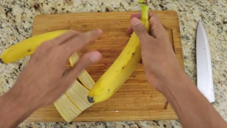 peeling bananas with hands, pov shot from top