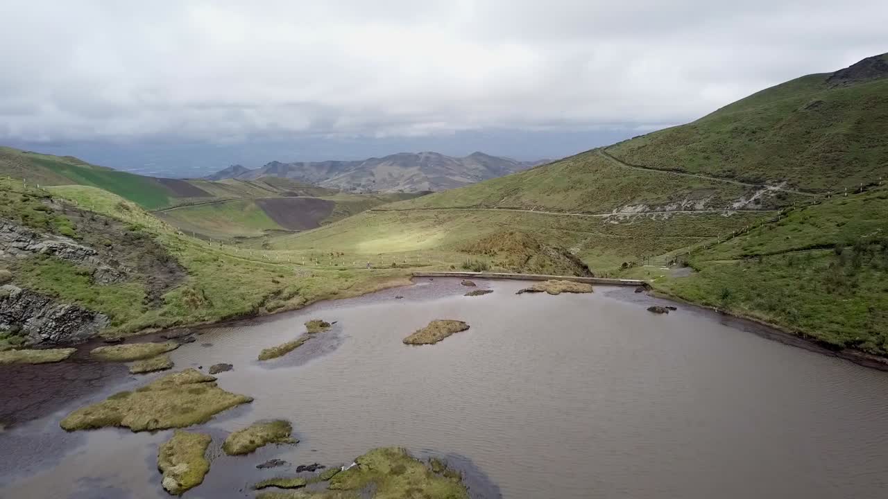 Majestic mountain top lake with dam in flying forward aerial view