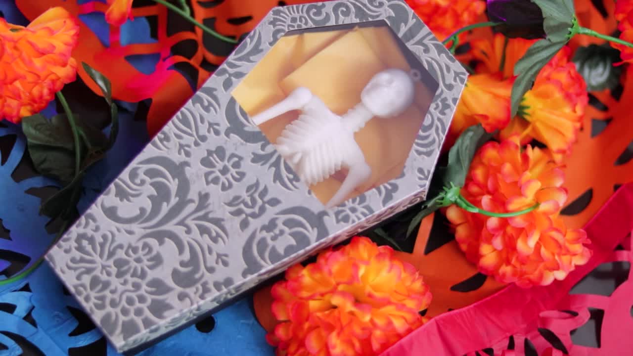 pequeño cráneo dentro de una caja, simulando un ataúd, como una decoración para el día de los muertos