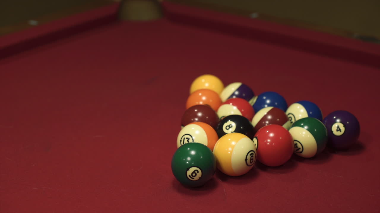 Slow motion medium wide shot of billiard balls being struck
