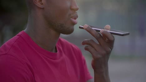 closeup of young male mouth talking on phone with speakerphone