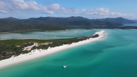 Velero-Flotando-En-La-Orilla-De-La-Playa-De-Whitehaven-Con-Arena-De-Sílice-Más-Blanca-Y-Vegetación-Densa-En-Whitsundays,-Norte-De-Queensland,-Australia