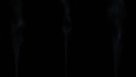 3 rápidas corrientes de humo blanco que se elevan contra un negro
