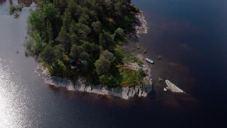 Draufsicht-Auf-Ein-Holzboot-Auf-Einer-Kleinen,-Mit-Baumwäldern-Bedeckten-Insel