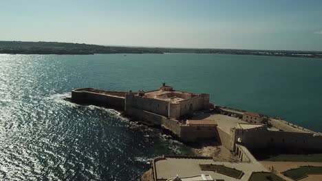 Vuelo-De-Drones-Hacia-El-Castello-Maniace-En-La-Isla-De-Ortigya,-Siracusa,-Sicilia,-Italia