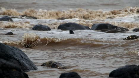 Feroces-Olas-En-La-Playa-Que-Golpean-El-Coral-Negro-Con-Enfoque-Selectivo