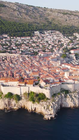 drone capturing the walled city of dubrovnik, croatia, with its distinctive terracotta rooftops and historic fortifications. vertical video