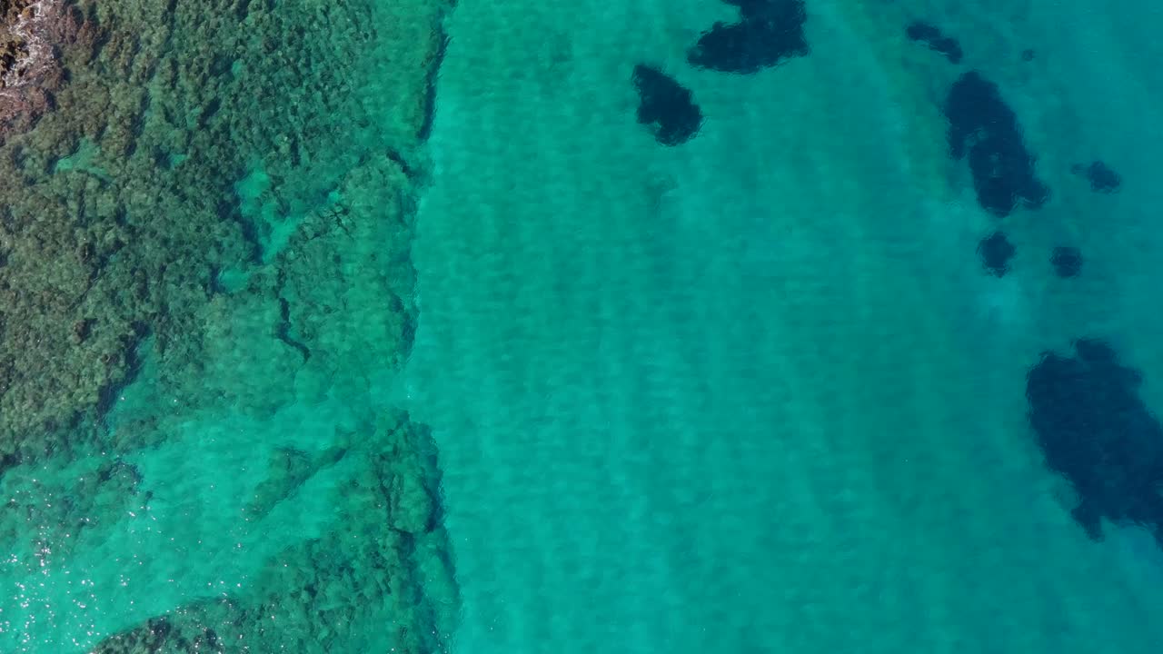 Aerial - crystal-clear waters along rocky Crete coastline, Greece, turquoise and serene