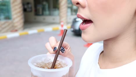 person eating noodles with chopsticks on the street.