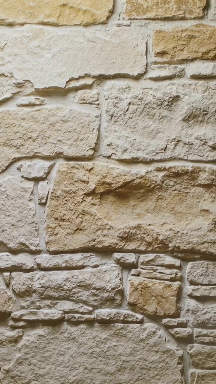 Video verticale: Primo piano di blocchi di pietra con malta all'interno di una stanza, per la texture.