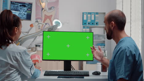el dentista y el enfermero analizan la pantalla verde en la computadora
