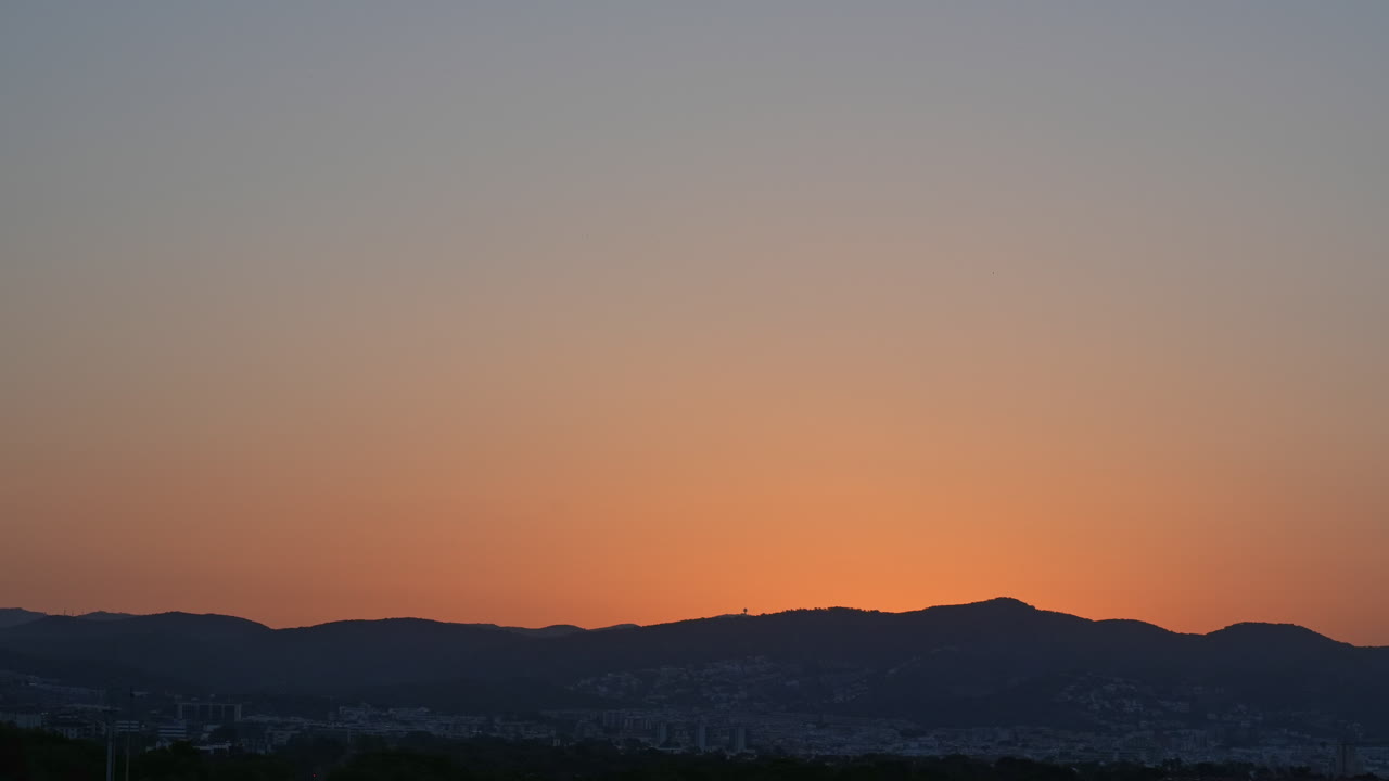 화려한 타임  ⁇ 스는 산맥 위의 황금빛 일출을 영화적인 방식으로 포착합니다.