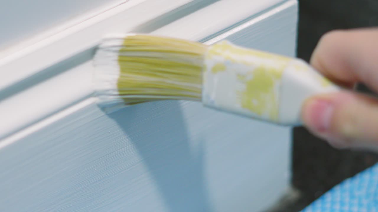 Close Up of Paintbrush Painting Floor Skirting Board White with Slow Motion Applying Paint with Strokes Back and Forth 4K