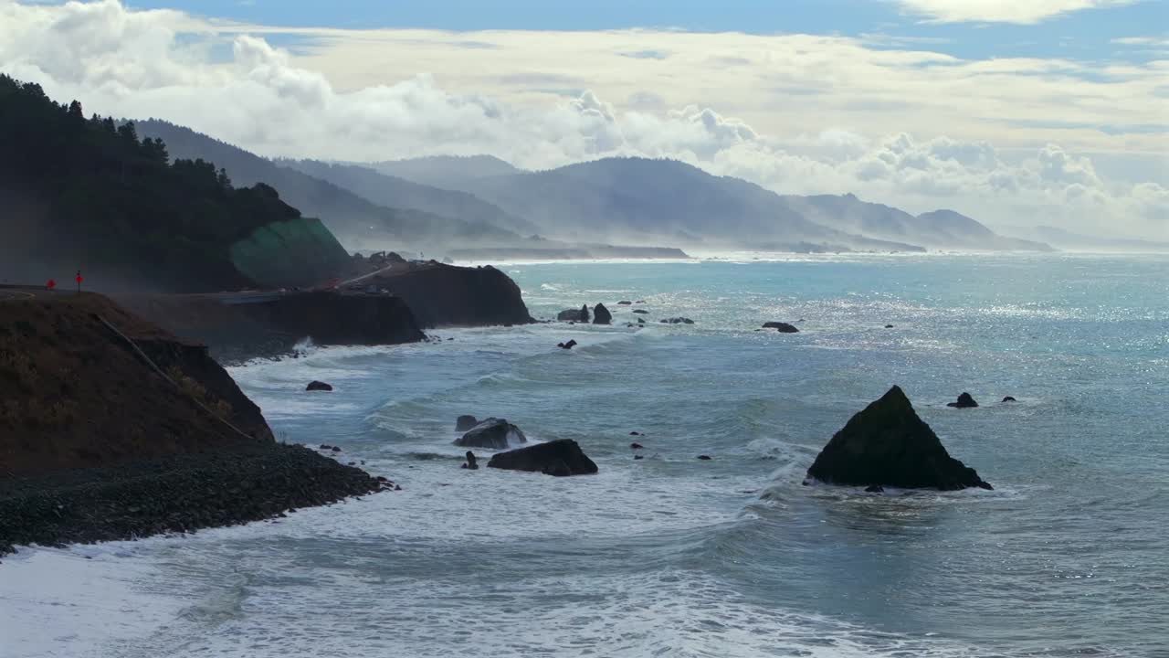 Shoreline Pacific Coastal Highway 1 DeHaven Westport Fort Bragg aerial drone California rugged Coastline blue sky surf waves crashing boulder rocks mountain side clouds sun Pacific Ocean upwards