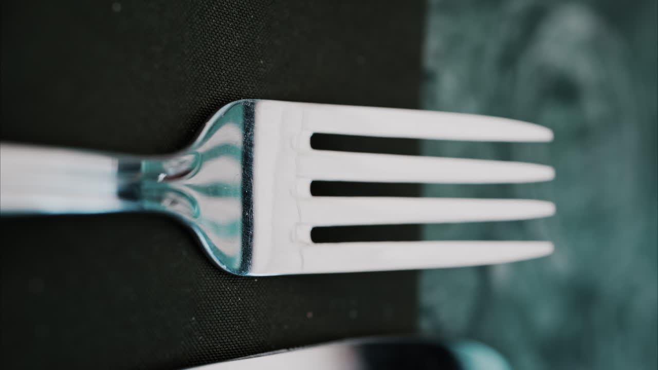 Close up of a fork on a green napkin. Vertical