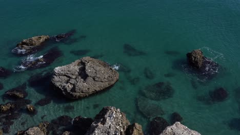 Pan-left-view-at-huge-rocks-in-Mediterranean-sea-near-seaside-town-Nerja