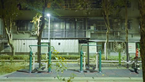 밤에 아파트 건물 밖의 타이페이의 운동 공원을 향해 과거 전면 나무를 밀어