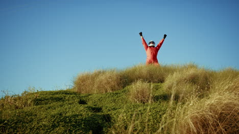 astronaut excited about discovering a new planet on top of mountain