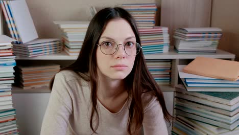 young brunette woman in glasses is thinking.