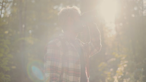 Young-Man-Looking-Through-Binocular-In-Forest