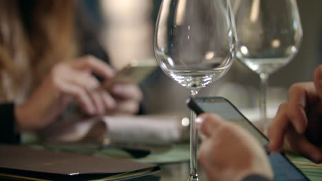 male hands using mobile phone in cafe. business couple using phone in restaurant