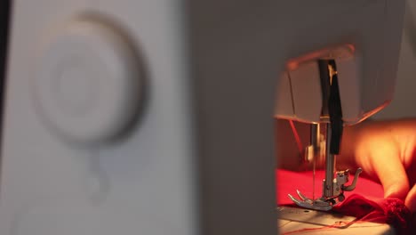 female hands use sewing machine on red dress in 4k
