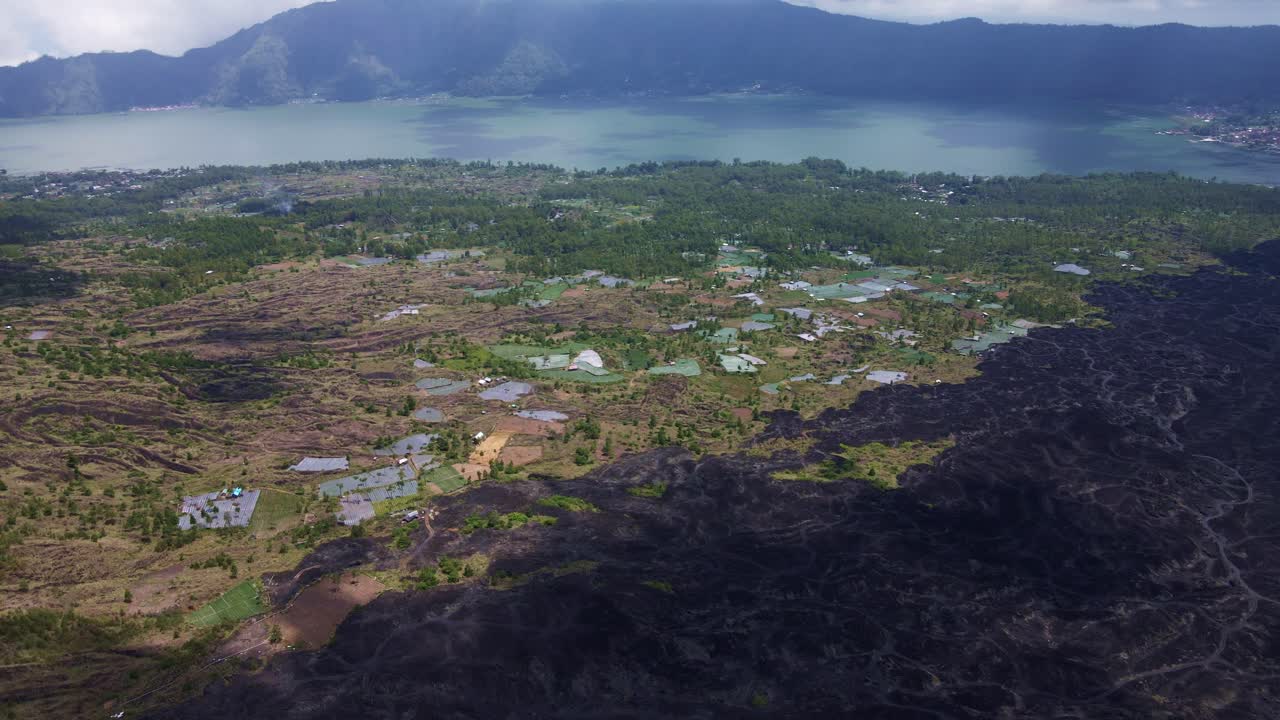 vista aérea del campo de lava cerca de tierras agrícolas en la ciudad rural de batur, bali indonesia