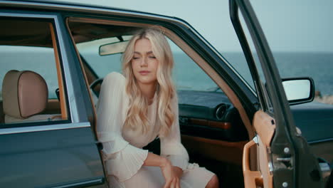 woman in vintage car by the ocean