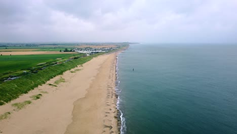 Aerial-shot-over-a-beautiful-beach-with-no-people-on-a-cloudy-early-morning