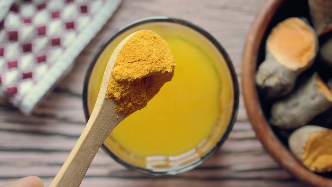 Adding Turmeric Powder to a Glass of Water