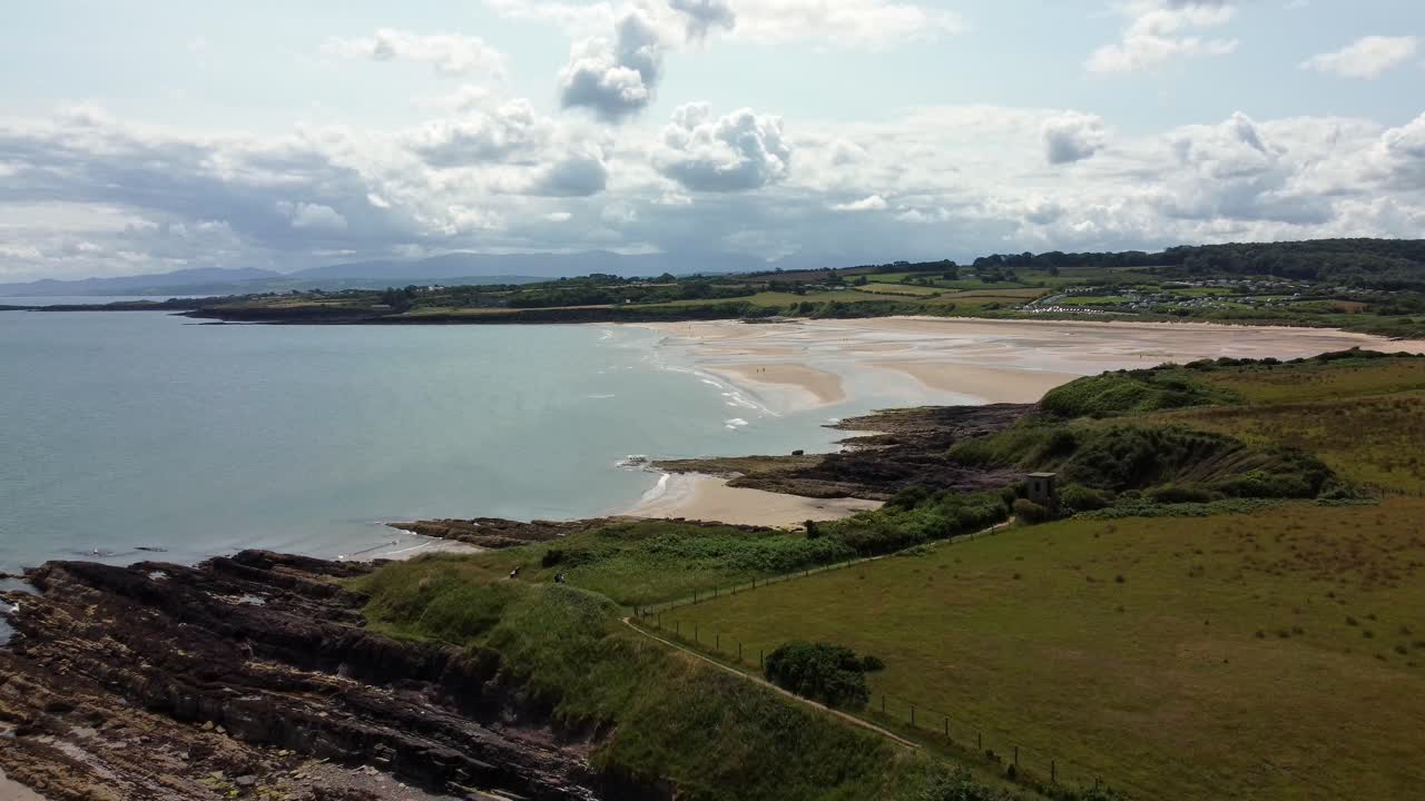 lethligwy idílica costa rocosa línea de costa vista aérea descendente a pastos verdes en el borde de acantilados rocosos