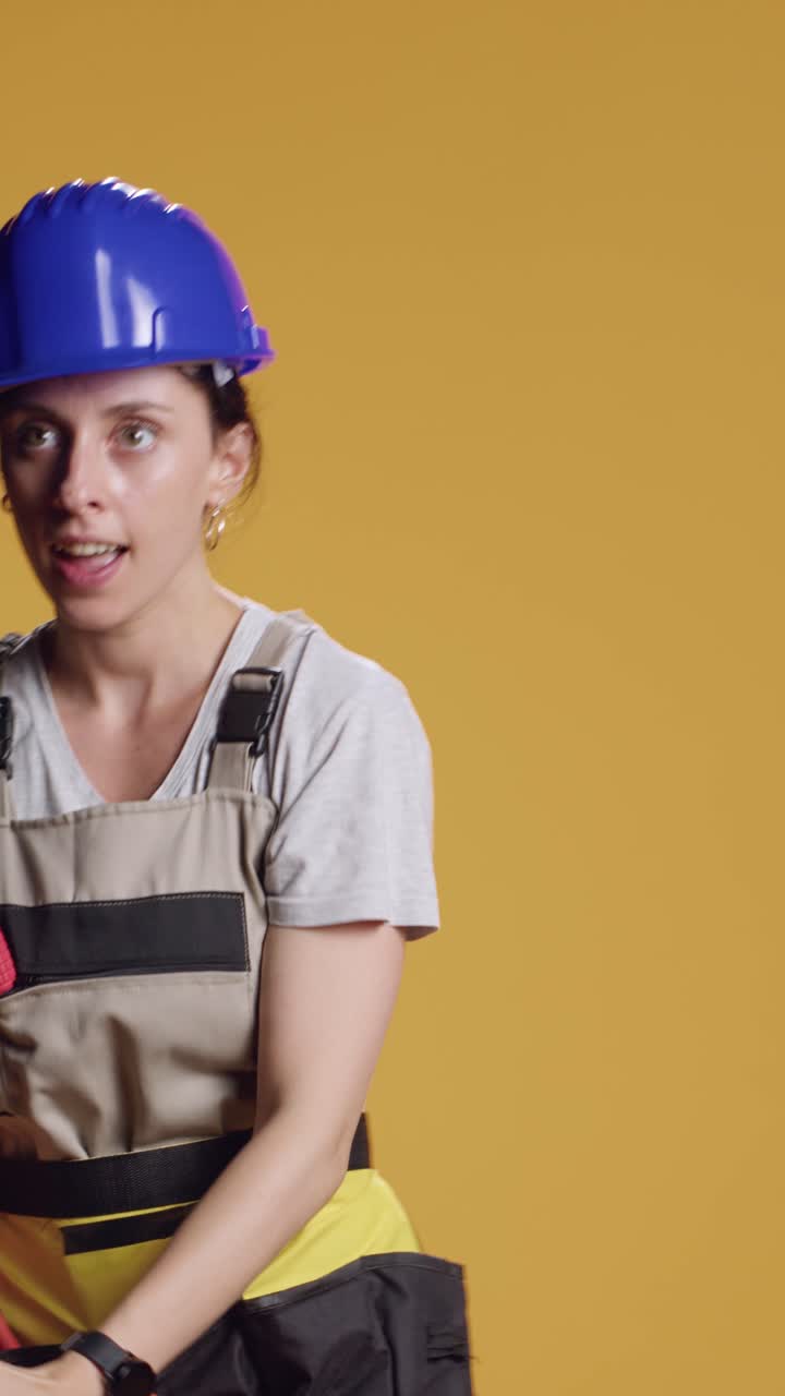 Vertical video: Construction worker having fun with power drill machine