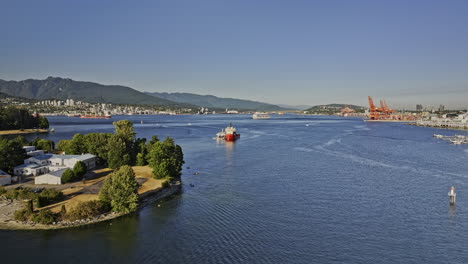 Vancouver-BC-Canada-Aerial-v34-low-drone-flyover-the-harbour-capturing-ships-on-the-calm-water,-shipyards-at-Downtown-Eastside-and-North-shore-mountain-views---Shot-with-Mavic-3-Pro-Cine---July-2023