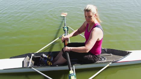 Portrait-of-senior-caucasian-woman-preparing-rowing-boat-in-a-river