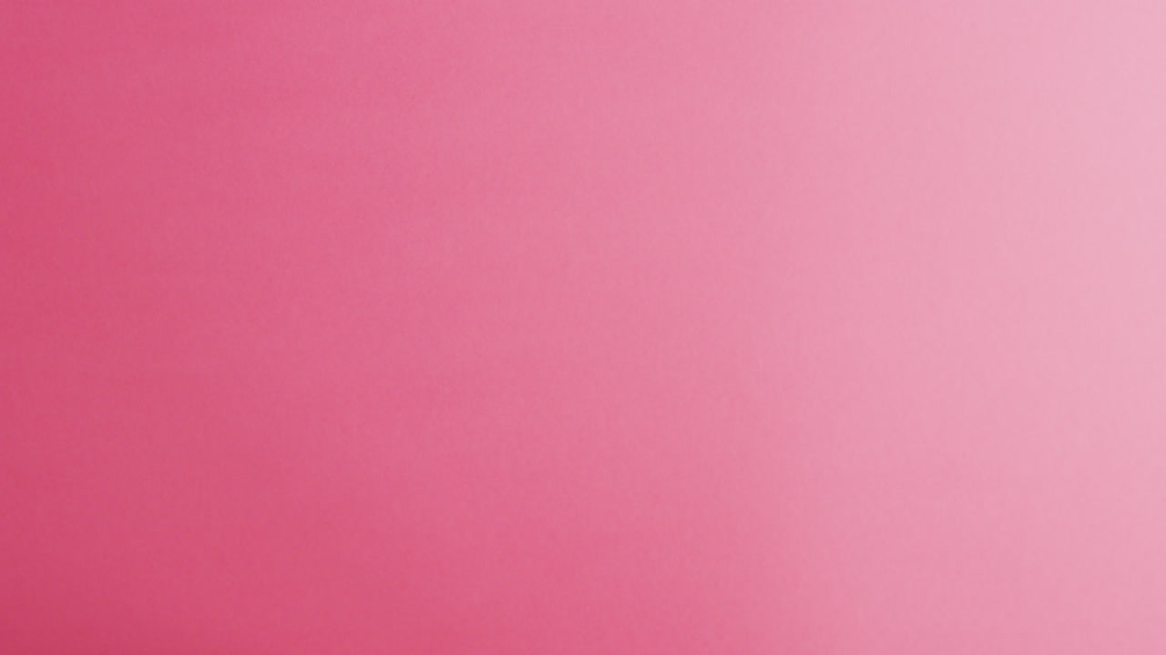 video de las manos de una mujer caucásica sosteniendo una cinta rosa sobre un fondo rosa