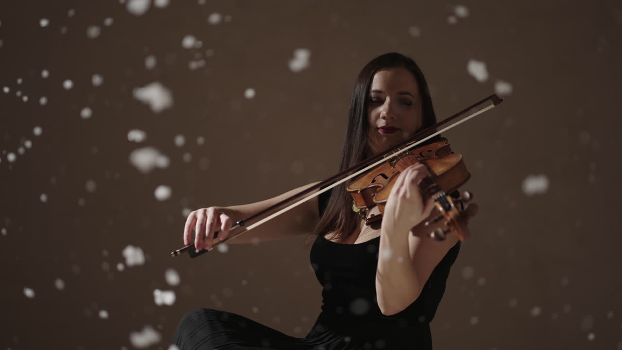 mujer tocando el violín con efecto de nieve