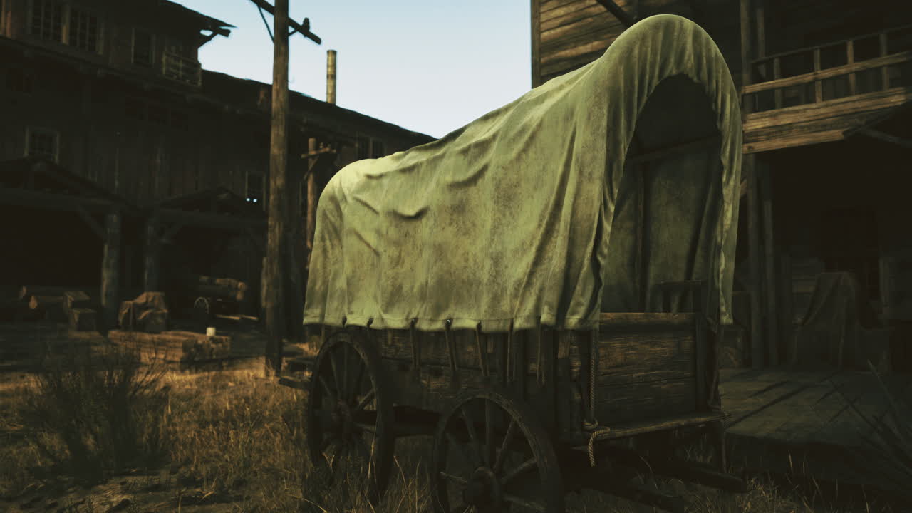 Old wooden wagon covered with fabric in a deserted town during sunset