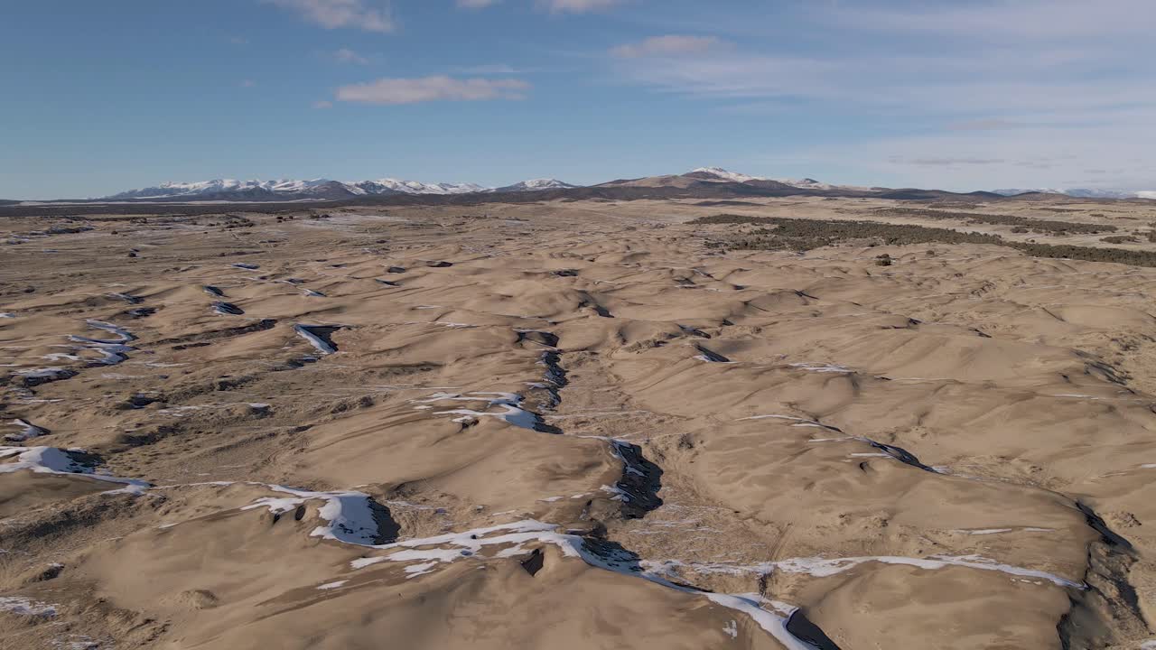 pequeñas dunas de arena del desierto del sahara y montañas distantes de utah en invierno