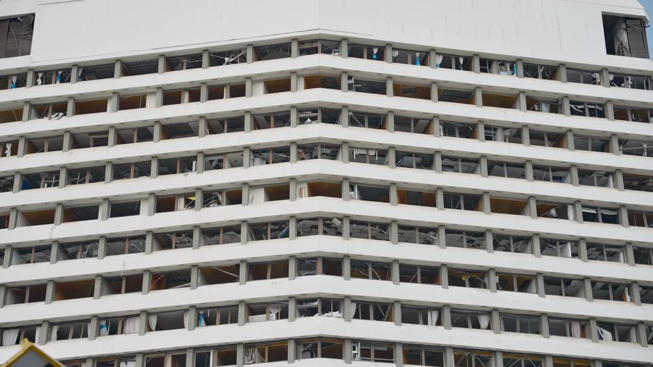 Edificio abbandonato e fatiscente. Finestre rotte o mancanti, interni in macerie e metallo contorto. Trascuratezza e demolizione. Scenario post-apocalittico. Attacco terroristico. Abitazioni danneggiate