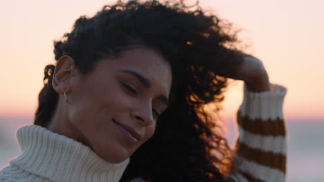 retrato de una hermosa mujer hispana disfrutando de la tranquilidad de la playa al atardecer explorando la atención contemplando la espiritualidad con el viento soplando el cabello