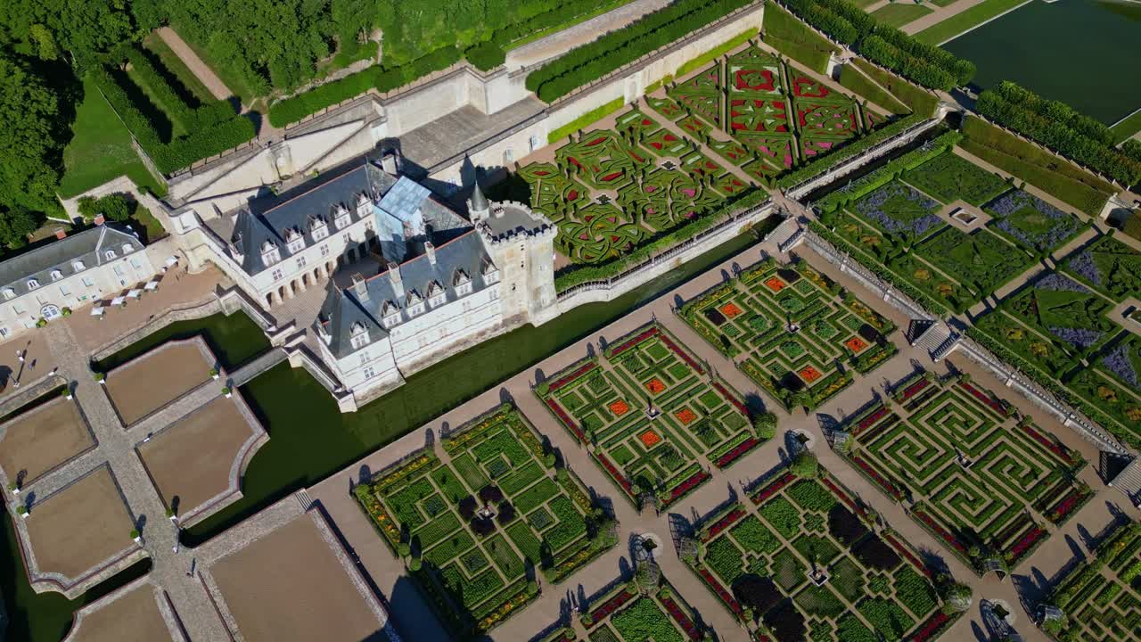 Aerial view of Château de Villandry, Renaissance gardens, castle with moat and manicured formal gardens, Loire Valley, France. Aerial top-down orbiting