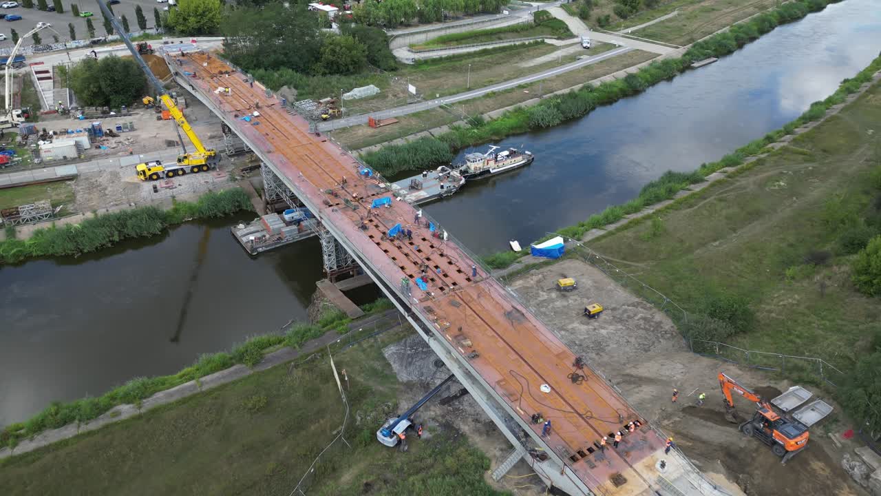 vista panorámica aérea a la derecha con vistas al sitio de construcción del puente para peatones y bicicletas sobre el río warta en poznan, polonia, durante un día soleado de verano