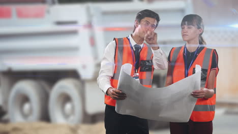 architects in hi vis vests discuss plans at a warehouse with a truck in the background.